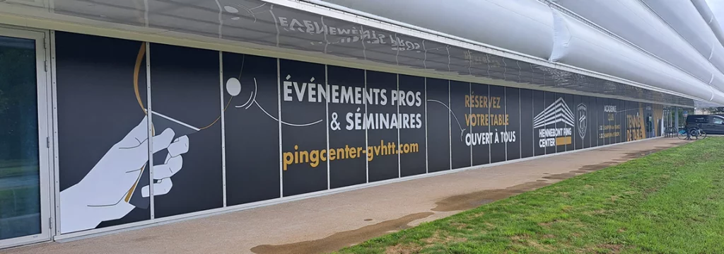 Vue côté gauche des baies vitrées du Hennebont Ping Center avec les illustrations vectorielles de mains jouant au tennis de table
