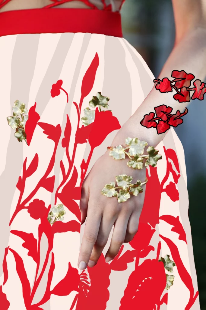 Illustration d’une main de mannequin avec robe vaporeuse et feuillage rouge, fond de robe opacifié, morceaux du bracelet en or incrustés dans le feuillage, et ajout d’un bracelet rouge inspiré de la robe