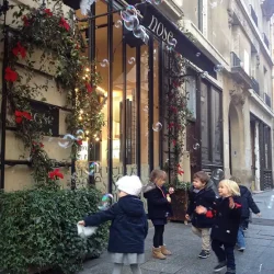 Façade de la boutique Nose décorée pour Noël avec des enfants jouant avec les bulles